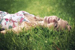 Smiling woman lying in the grass.
